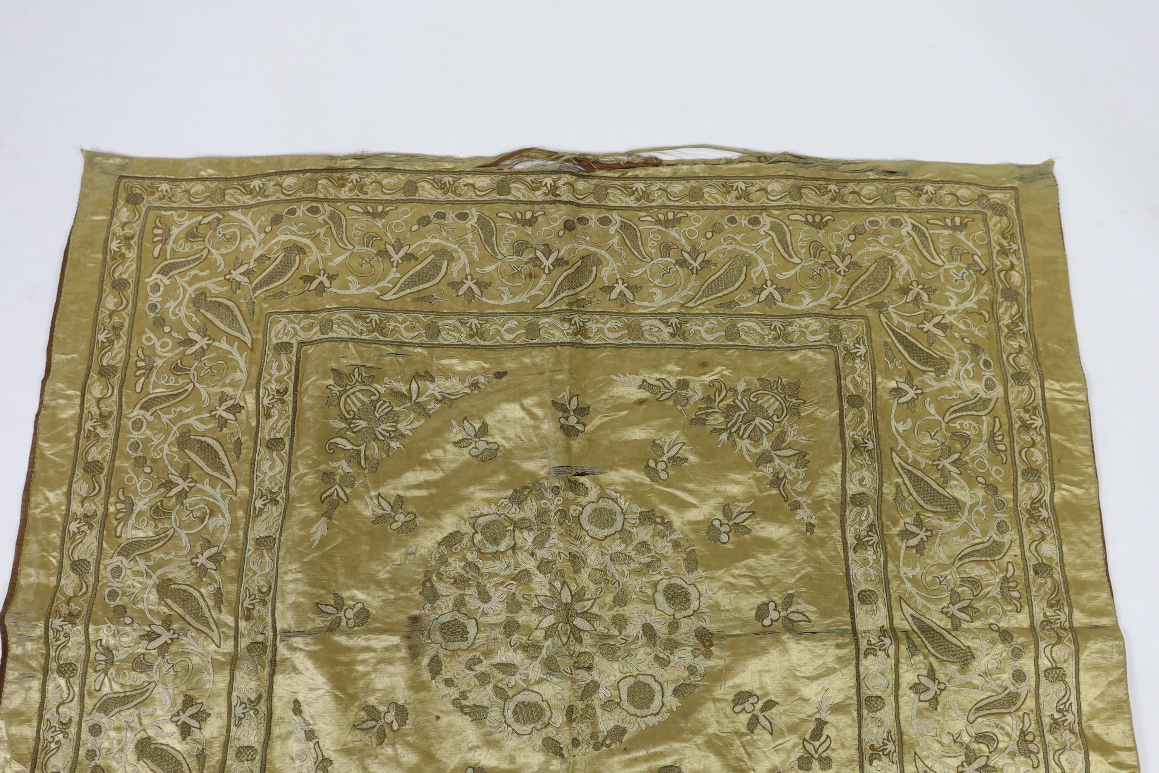 A late 19th century Turkish metallic thread and chain stitch silk satin cover, embroidered with a central cartouche of flowers and print, with rows of various borders with similar embroidery, 123 x 116cm